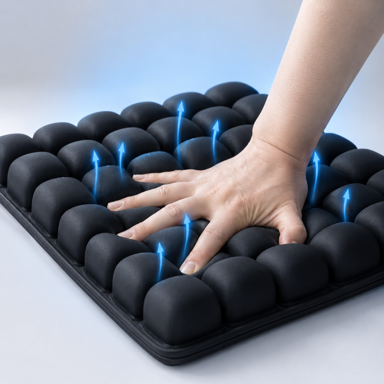 A hand pressing into the air cells with blue airflow lines rising between them